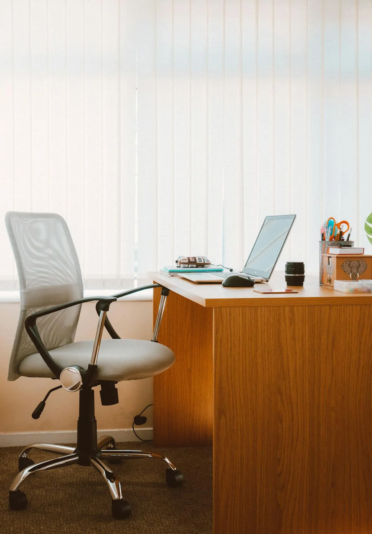 Modern office workspace with empty chair and natural lighting